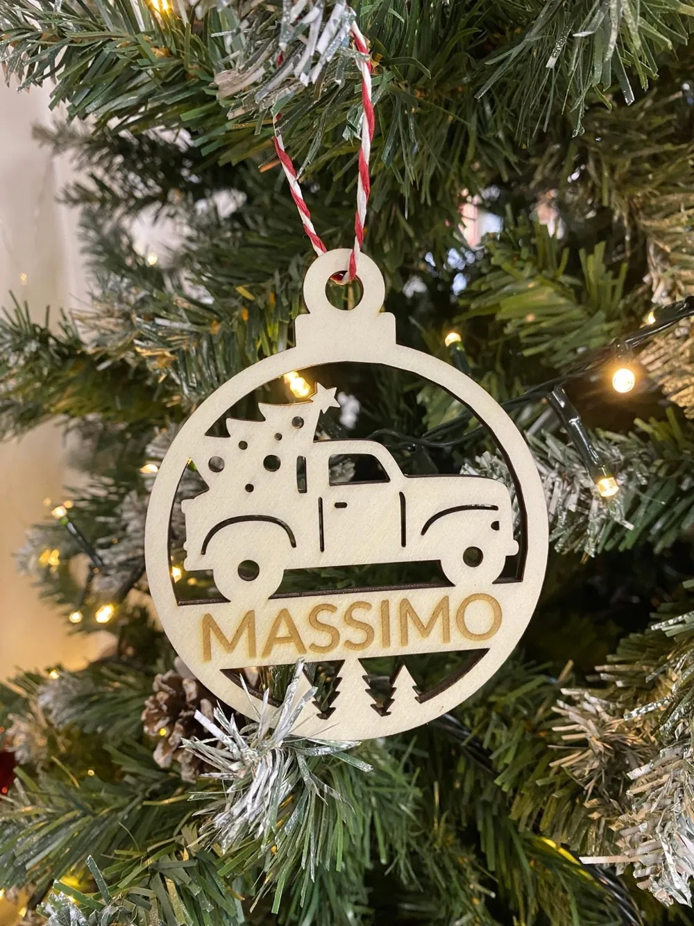 Pallina di Natale in legno con un furgoncino traforato e il nome Massimo, appesa all'albero